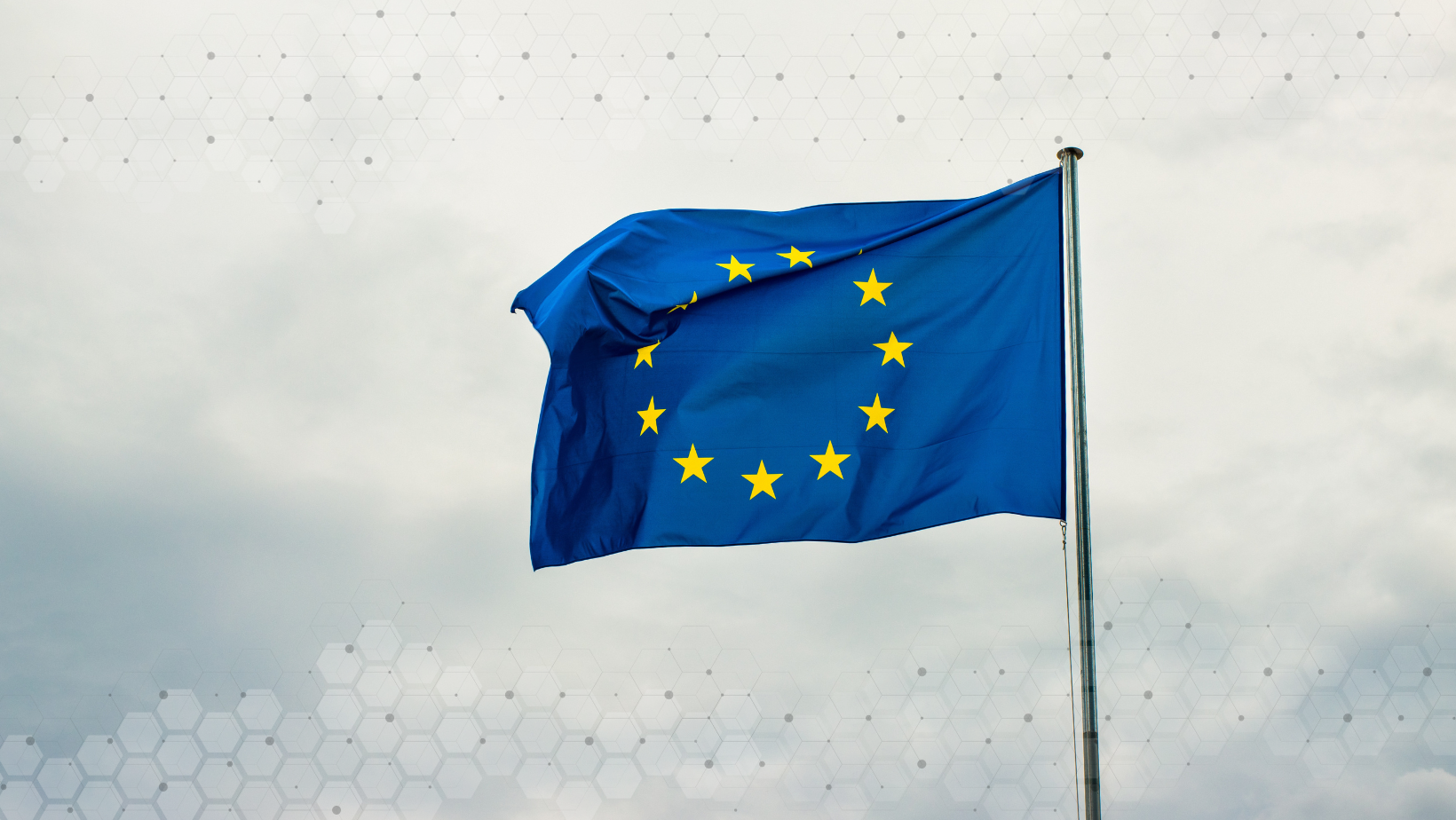 The European flag waving on a flagpole against a cloudy sky